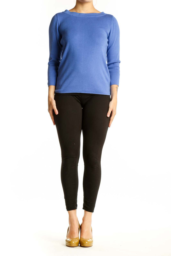Blue crew neck top with three-quarter sleeves worn with black pants, front view