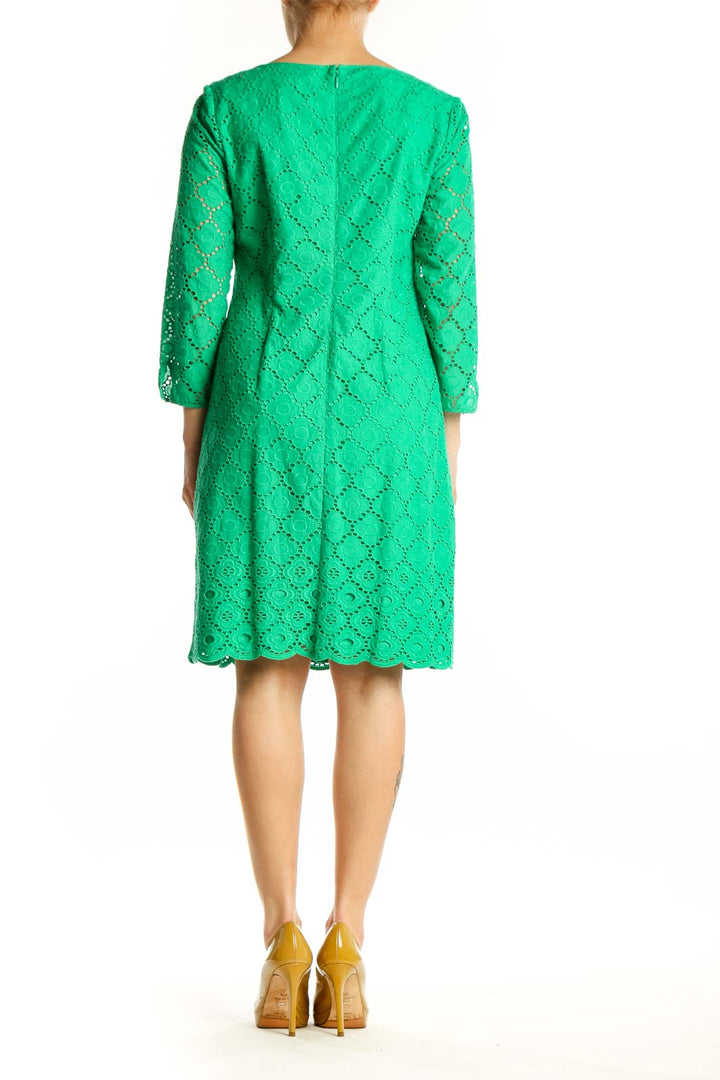 Back view of green eyelet lace A-line dress showing relaxed fit and midi length