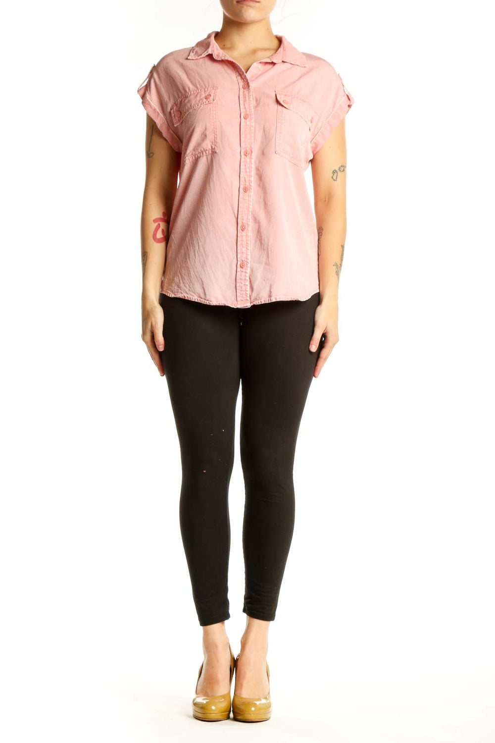 Pink short-sleeve button-up shirt with collared neckline and front pockets, worn with black pants