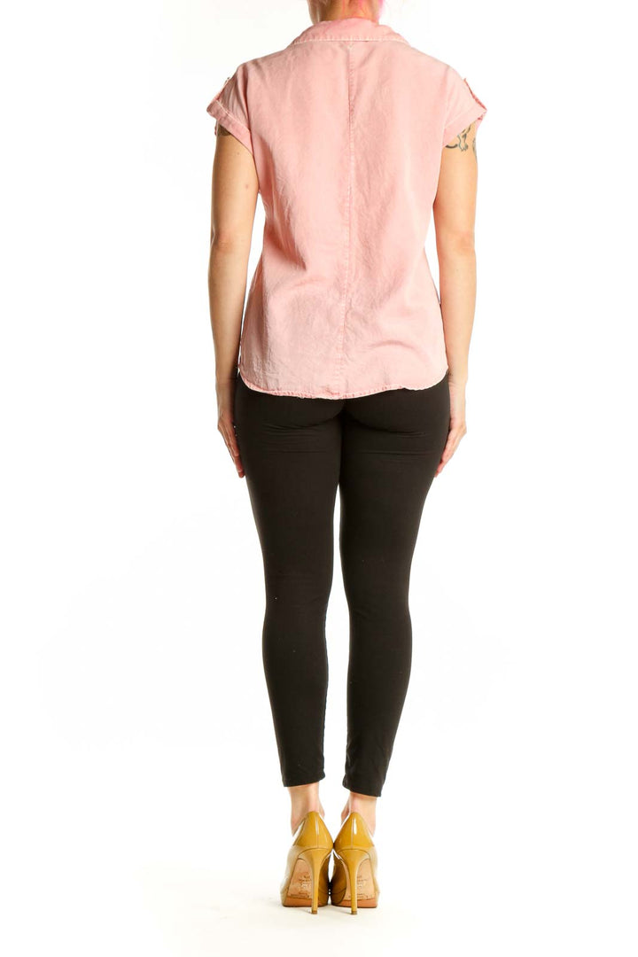 Back view of pink short-sleeve button-up shirt showing relaxed fit and rolled sleeves