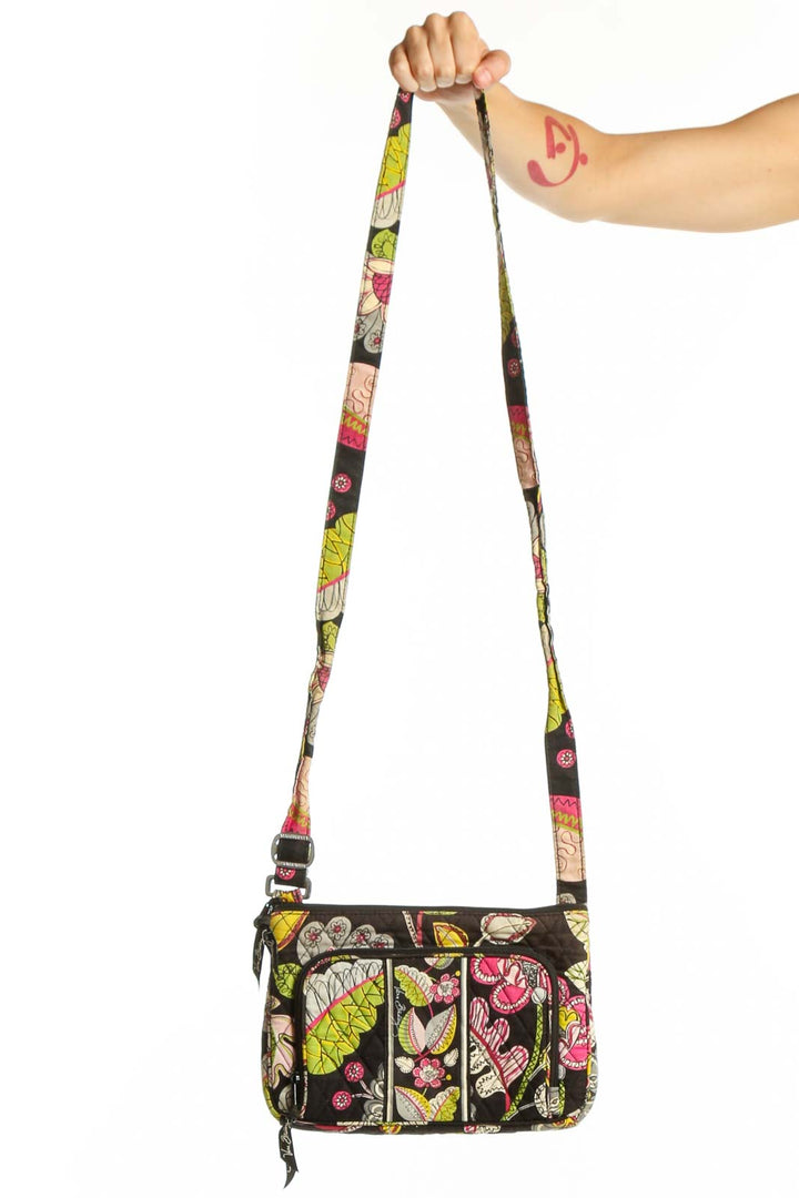 Black floral Vera Bradley crossbody bag with pink, yellow, and green botanical print and adjustable colorful strap