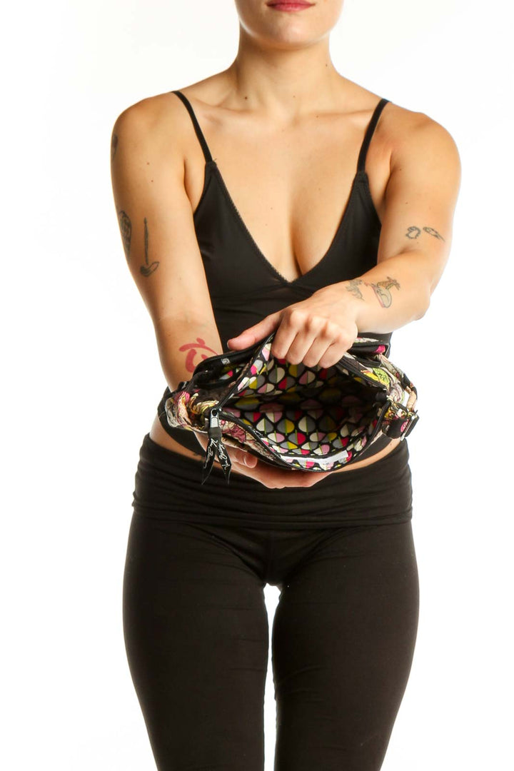 Back view of black floral Vera Bradley crossbody bag worn as crossbody style with adjustable patterned strap
