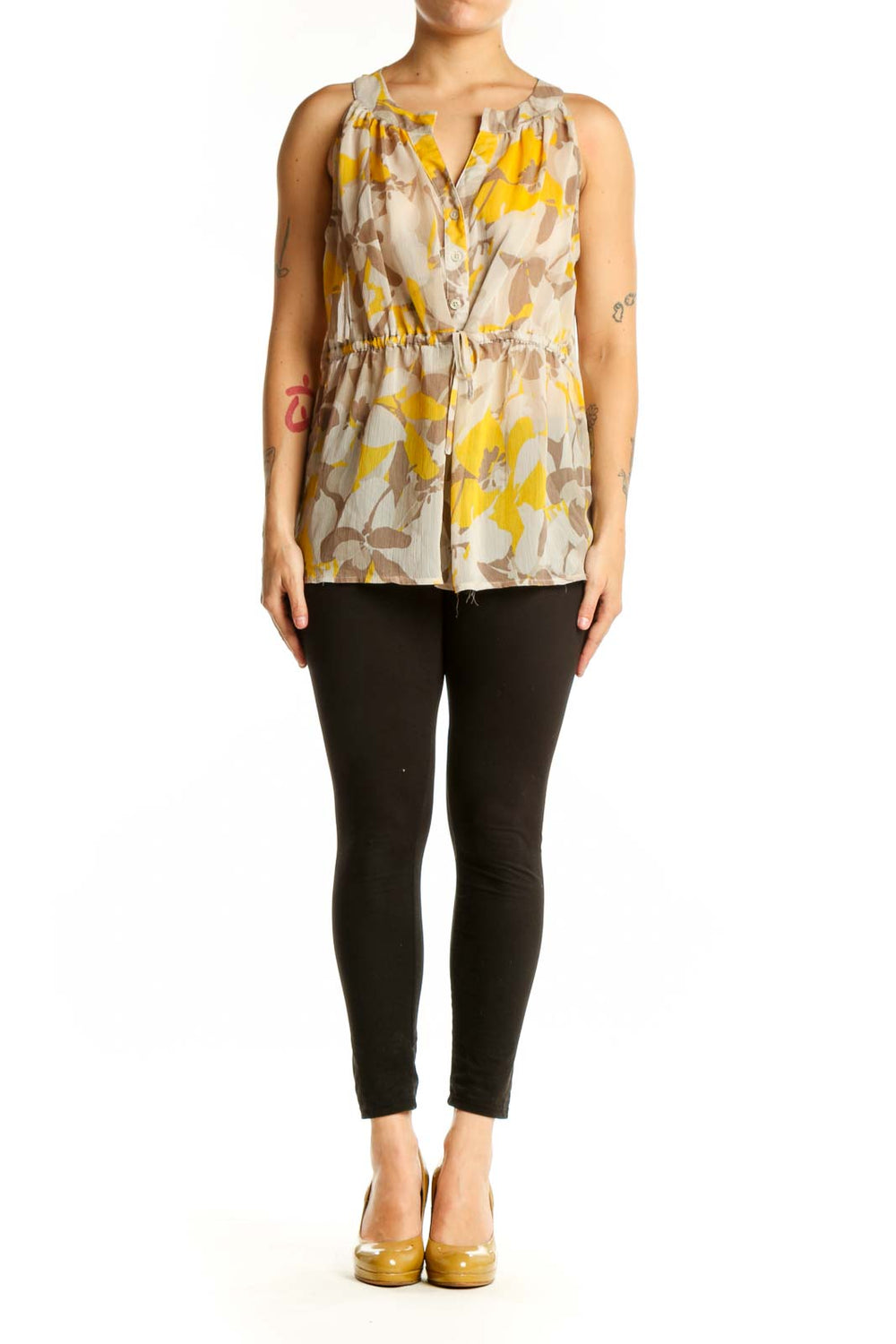 Gap yellow and taupe floral sleeveless top with V-neckline and button-front closure, worn with black pants