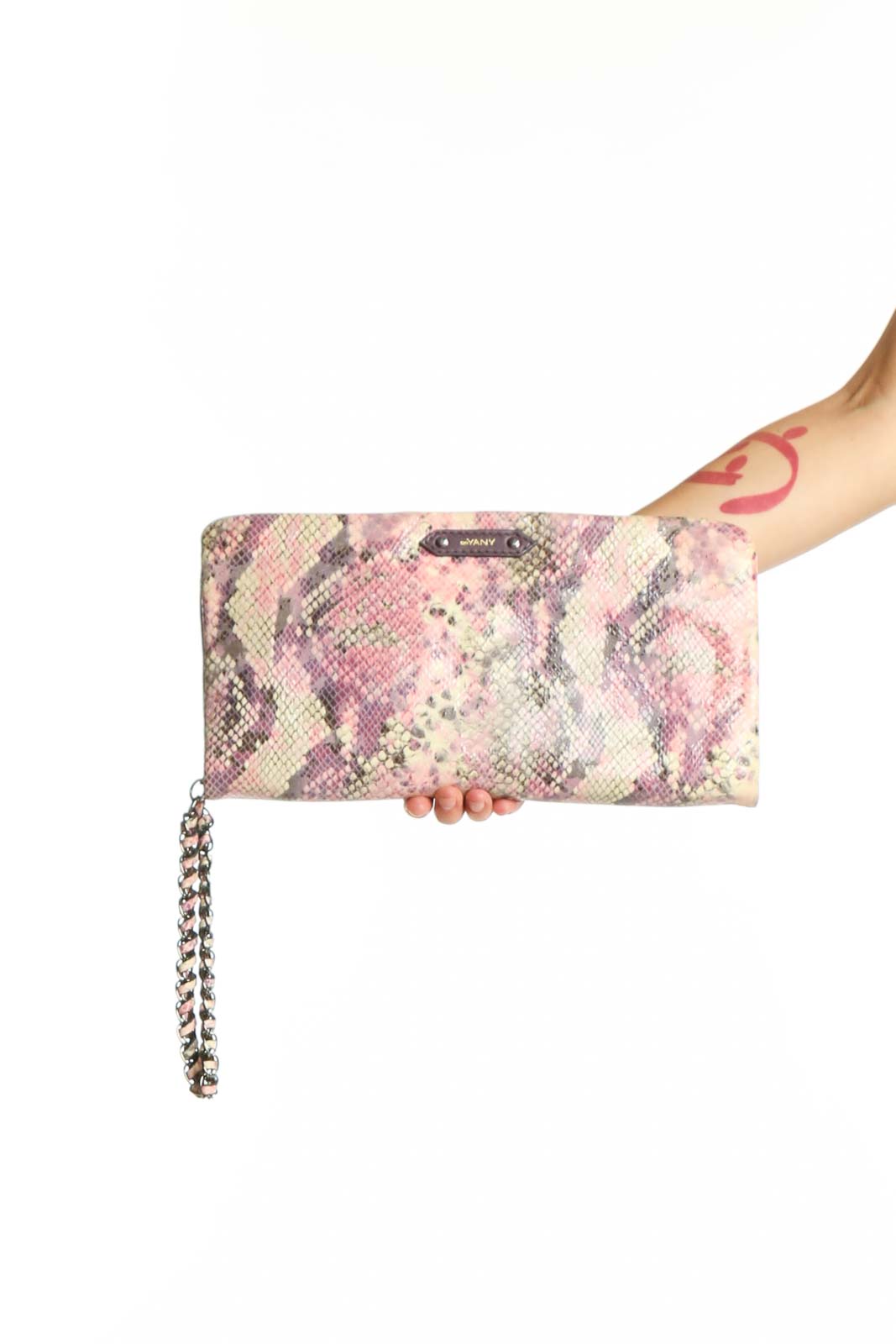 Pink and purple python print orYANY clutch with removable silver chain strap held in hand
