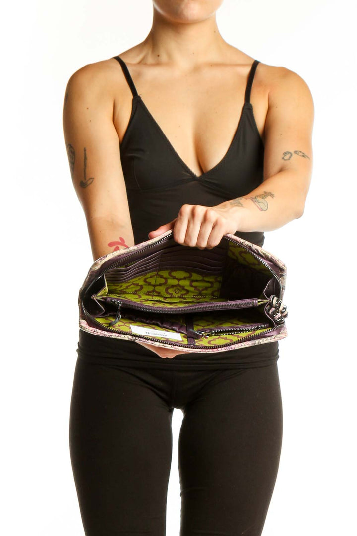 Pink python print orYANY clutch with chain strap styled with black outfit