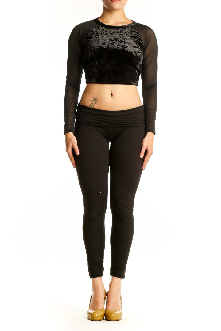 Black velvet crop top with sheer mesh long sleeves by Good American, front view on model