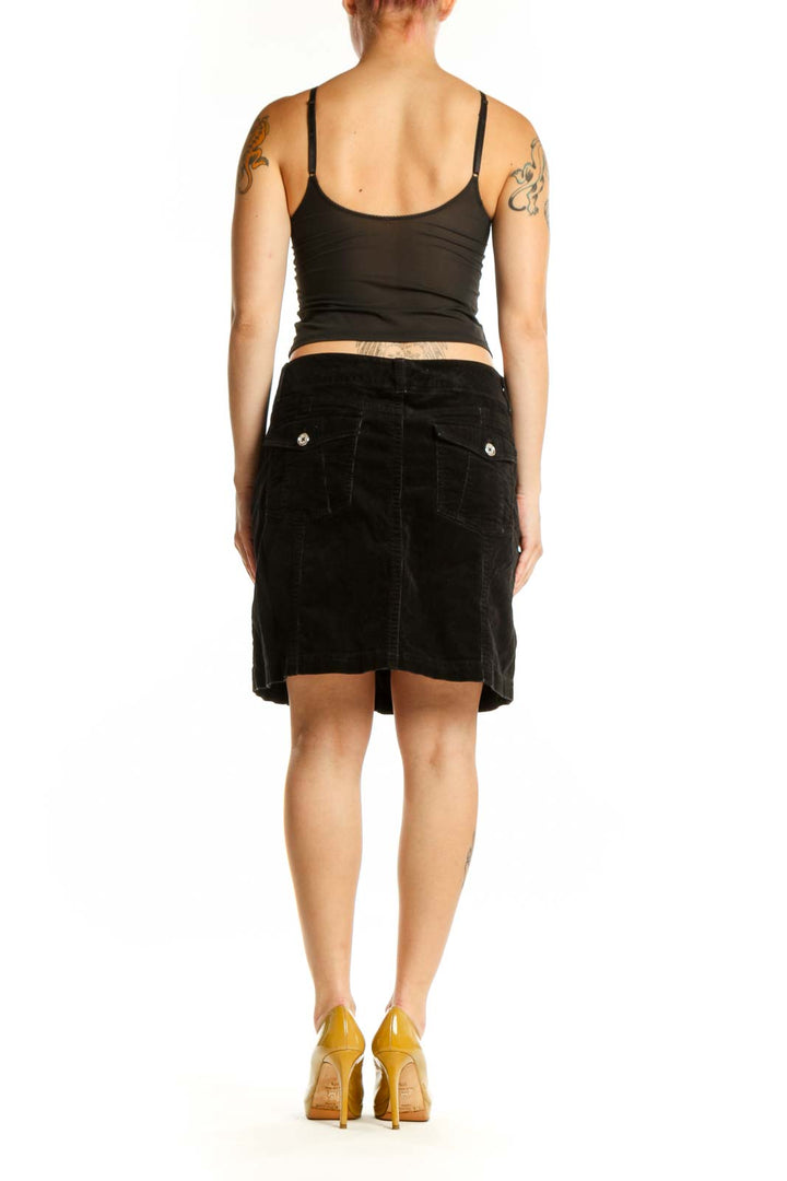 Black velvet mini skirt back view showing classic straight cut and refined design