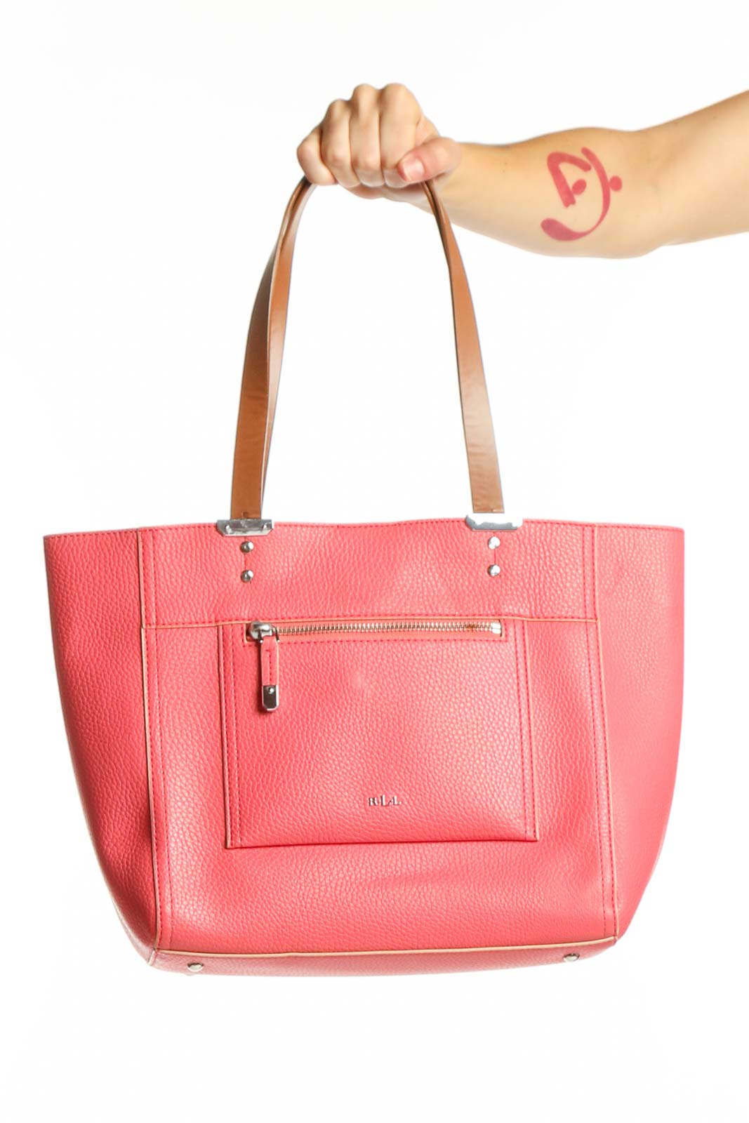 Pink polyurethane tote shoulder bag with dual tan leather handles and front zip pocket, held by model