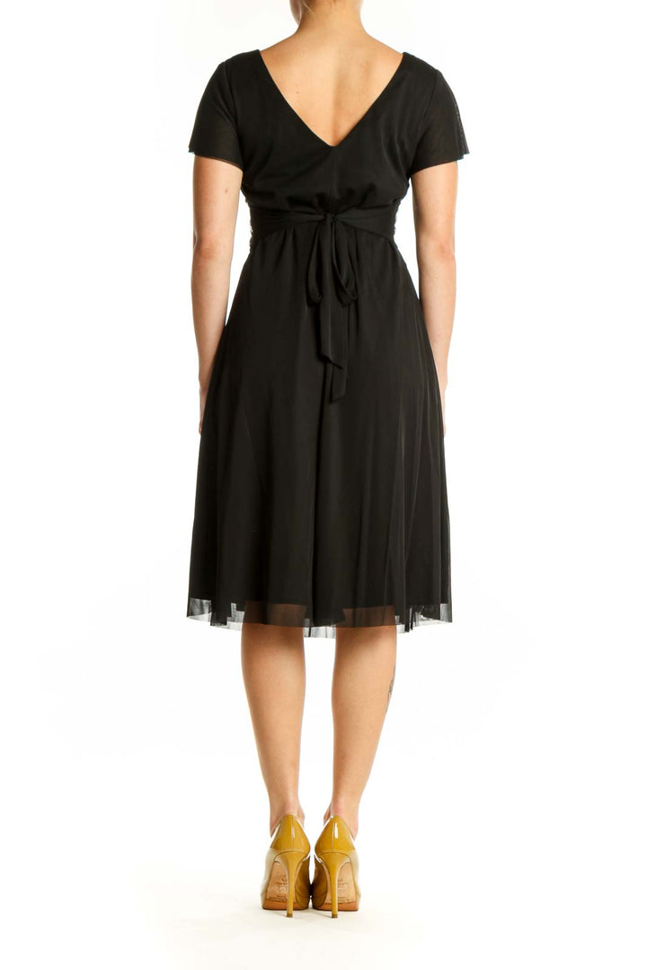 Black embellished empire waist midi dress with geometric beaded belt and flutter sleeves, back view