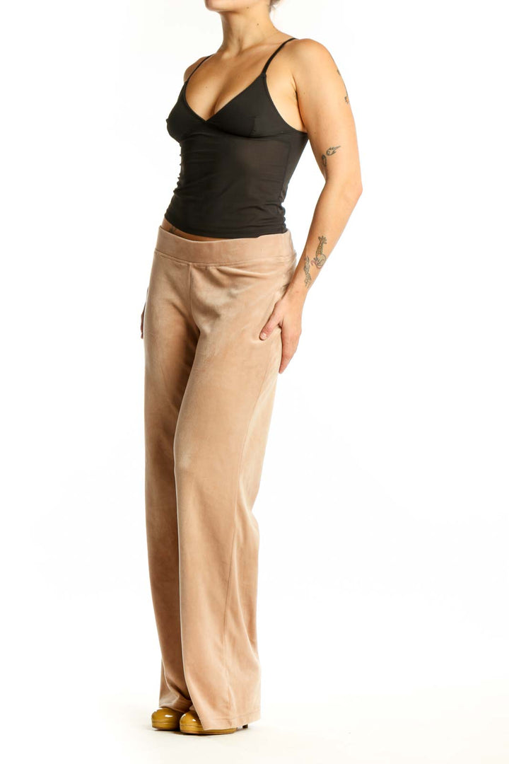 Beige velour activewear pants with elastic waistband, front view on model
