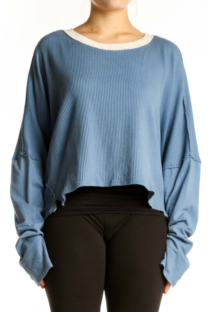 Blue ribbed cotton crop top with oversized sleeves and cream contrast trim, front view