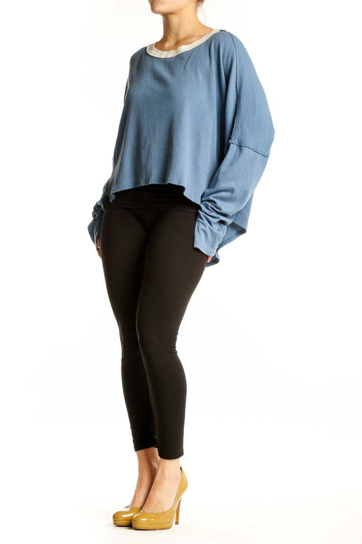 Blue ribbed cotton crop top with oversized sleeves and cream contrast trim, front view