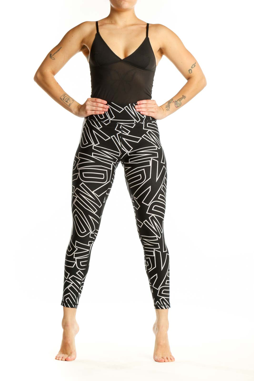 Black and white geometric print DKNY Sport leggings front view, high-waisted fit with abstract line pattern
