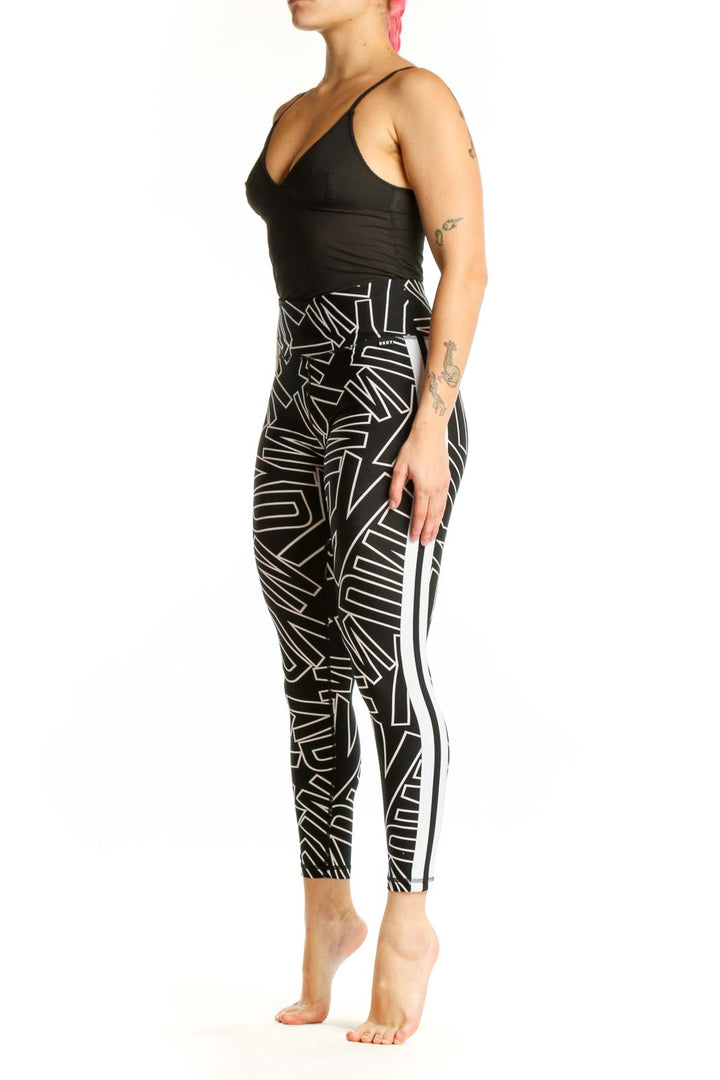 Black and white geometric print DKNY Sport leggings front view, high-waisted fit with abstract line pattern