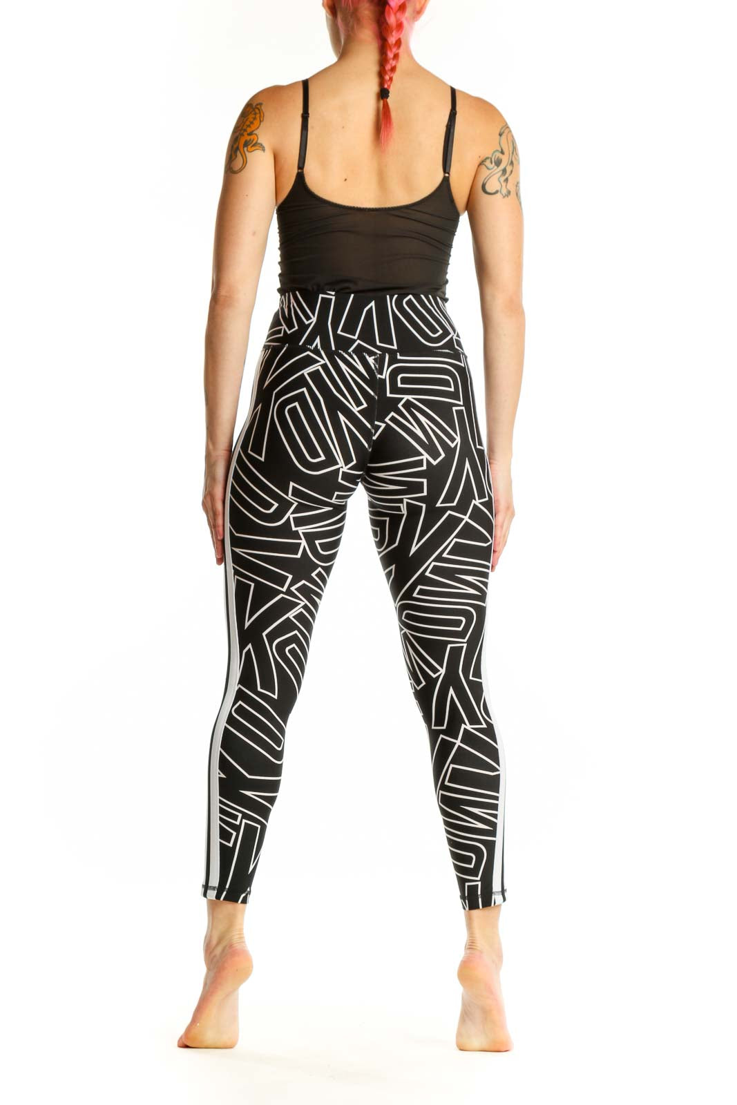 Black and white geometric print DKNY Sport leggings back view, showing side stripe detail and form-fitting silhouette