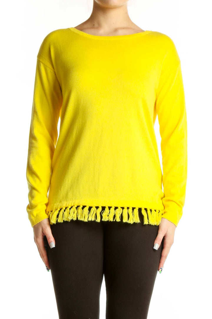 Yellow cashmere blend sweater with fringe trim worn with black pants, front view