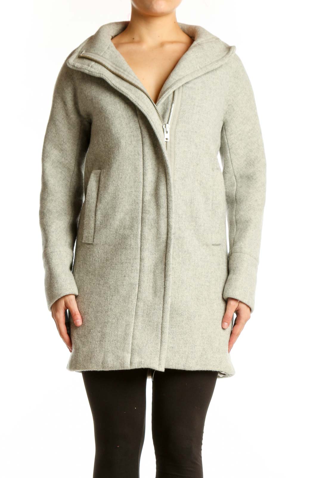 Woman wearing cream wool hooded zip-up coat with front pockets, paired with black leggings