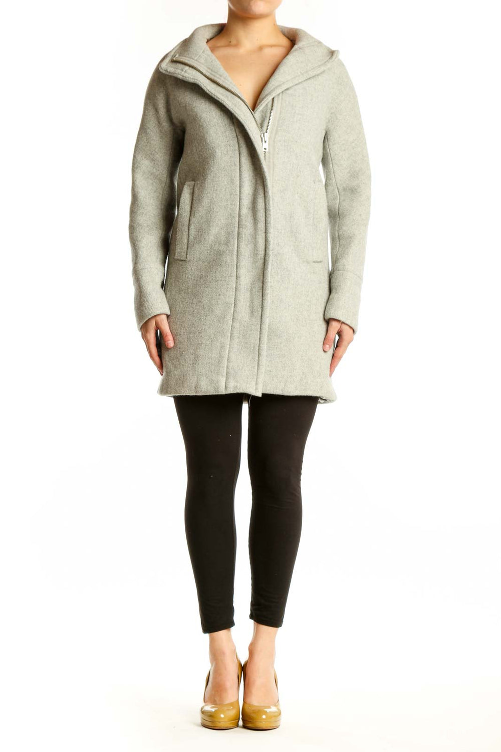 Woman wearing cream wool hooded zip-up coat with front pockets, paired with black leggings