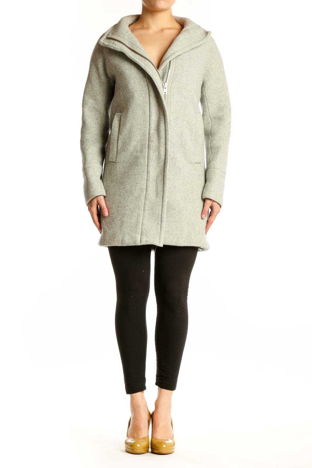 Woman wearing cream wool hooded zip-up coat with front pockets, paired with black leggings