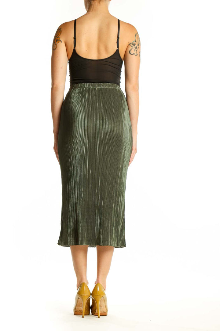 Back view of green pleated midi skirt showing the elegant drape and length of the pleated design