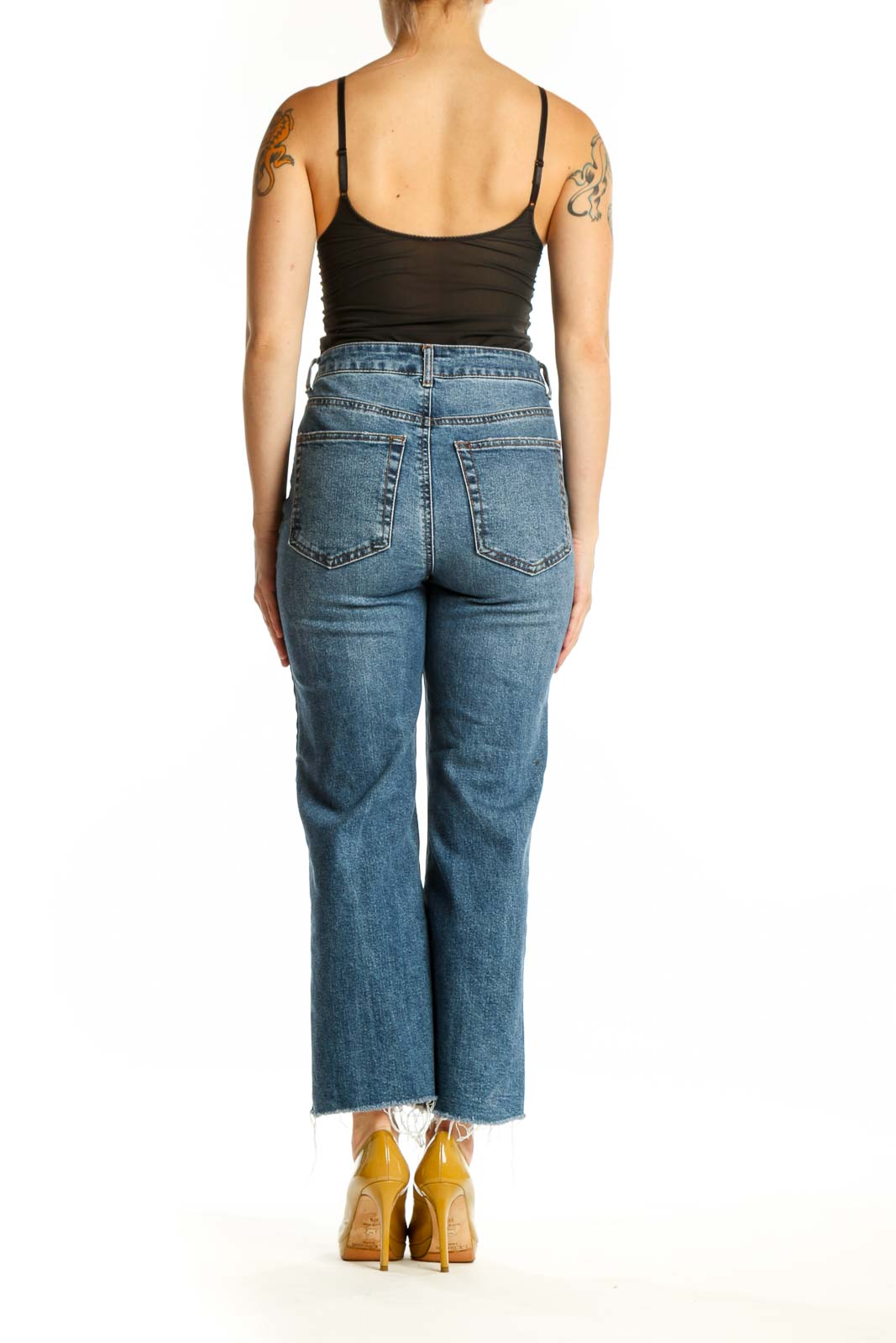 Back view of blue denim cropped jeans showing straight-leg silhouette and distressed ankle hem