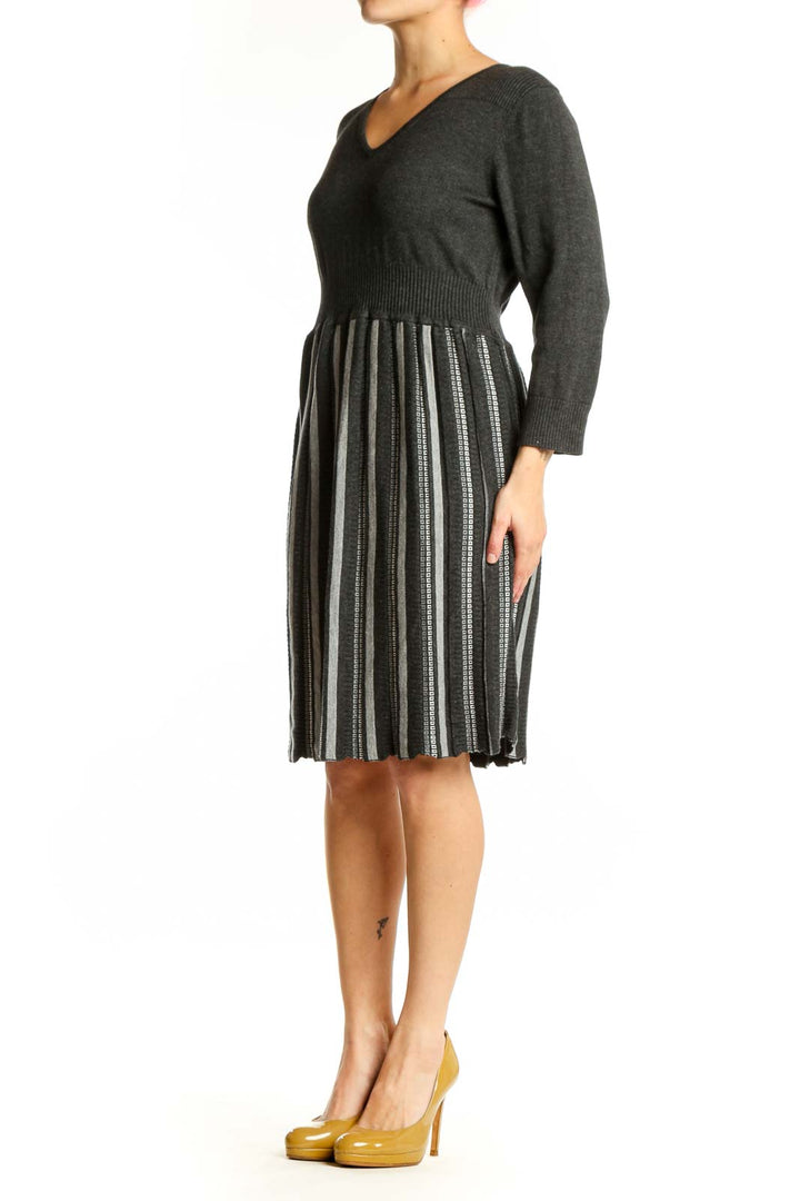 Front view of charcoal striped pleated knit dress with V-neckline and three-quarter sleeves