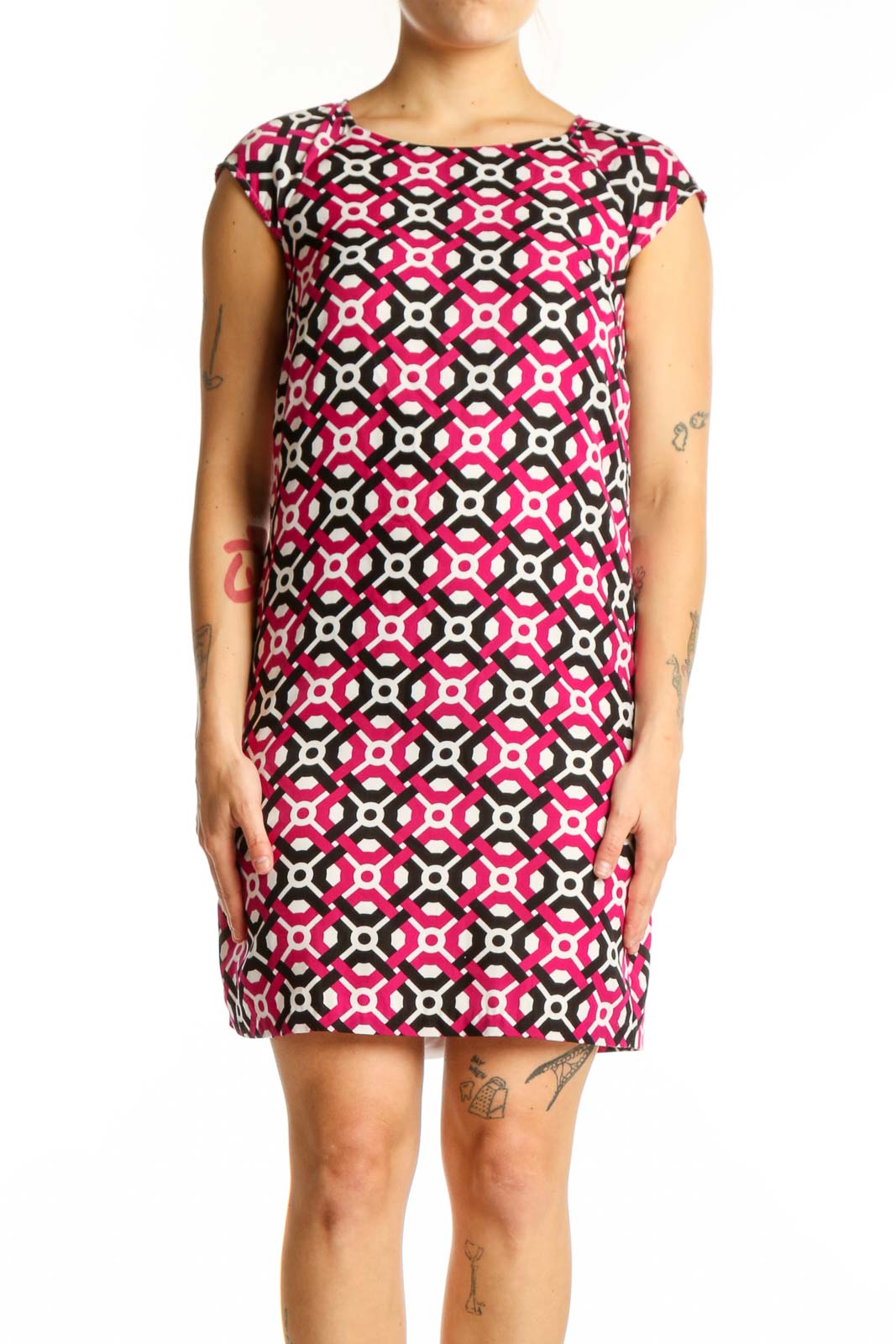 Front view of pink geometric print shift dress with black and white pattern, cap sleeves, and crew neckline