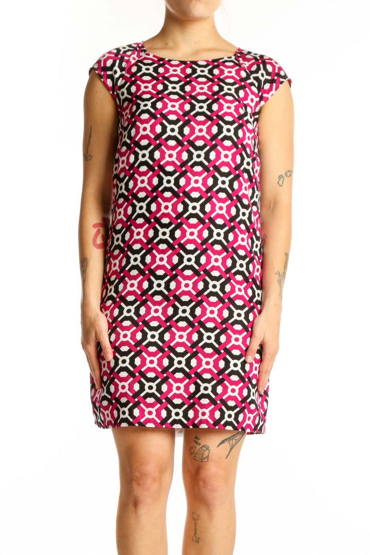 Front view of pink geometric print shift dress with black and white pattern, cap sleeves, and crew neckline