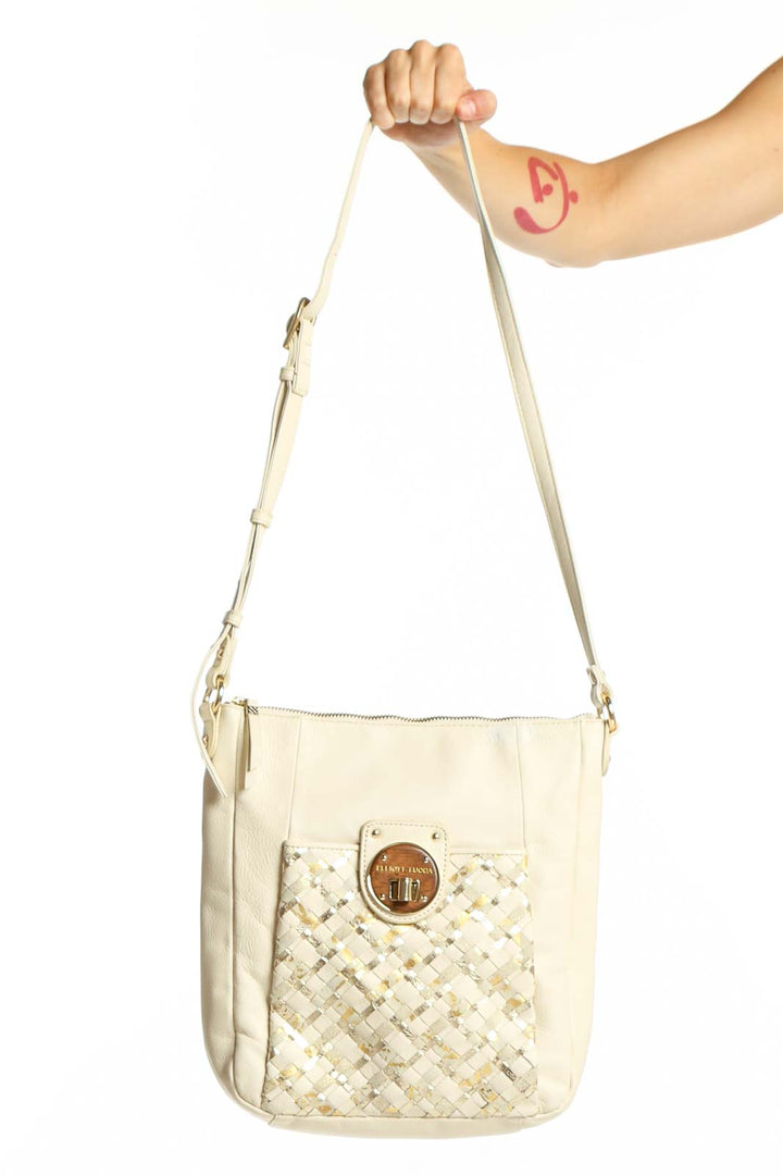 Cream quilted leather crossbody bag by Elliott Lucca with adjustable strap and gold circular hardware detail