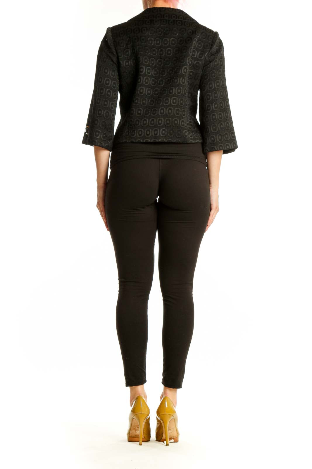 Back view of black geometric cropped jacket showing three-quarter sleeves and structured silhouette