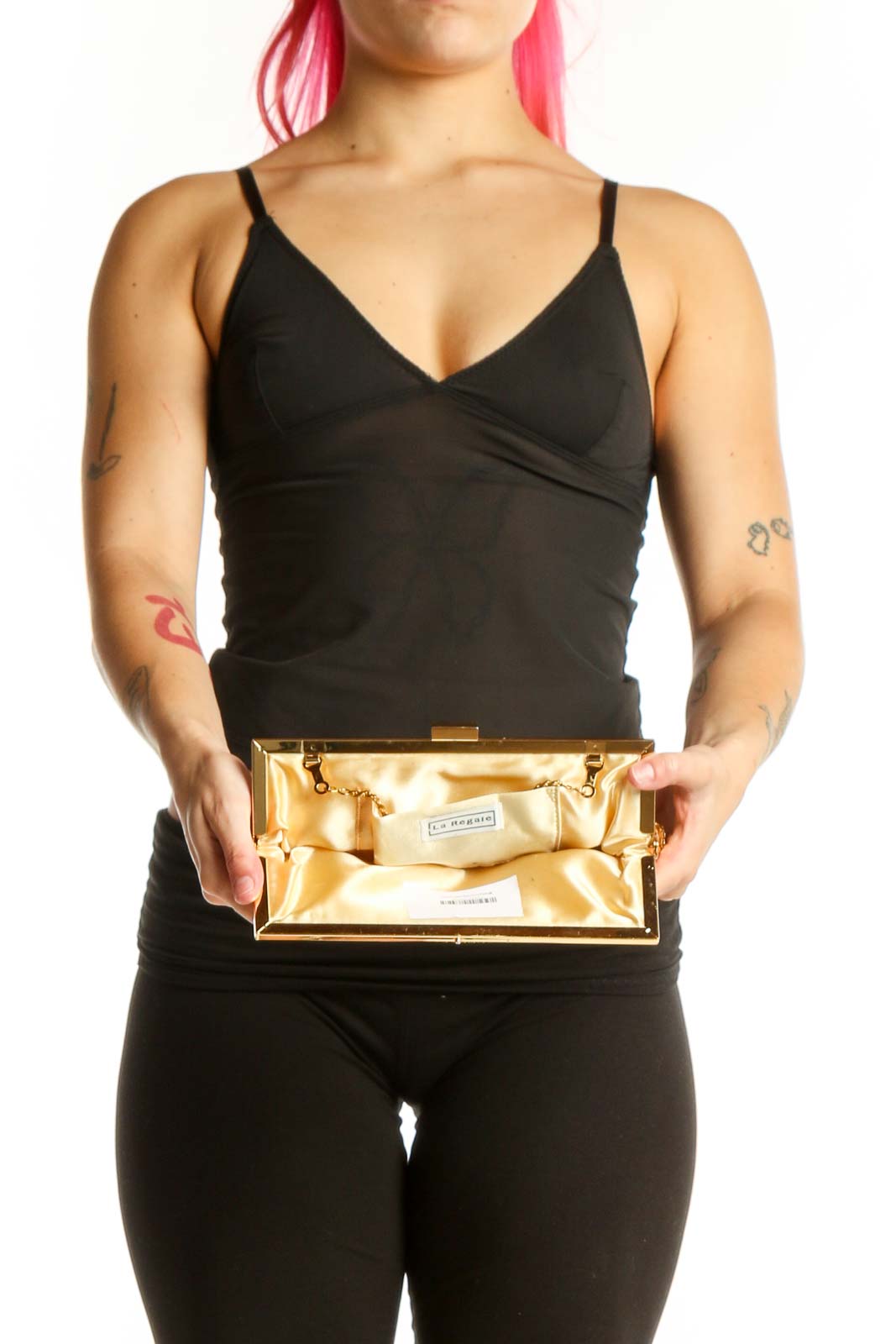 Gold sequin clutch worn as crossbody bag with chain strap on model in black outfit