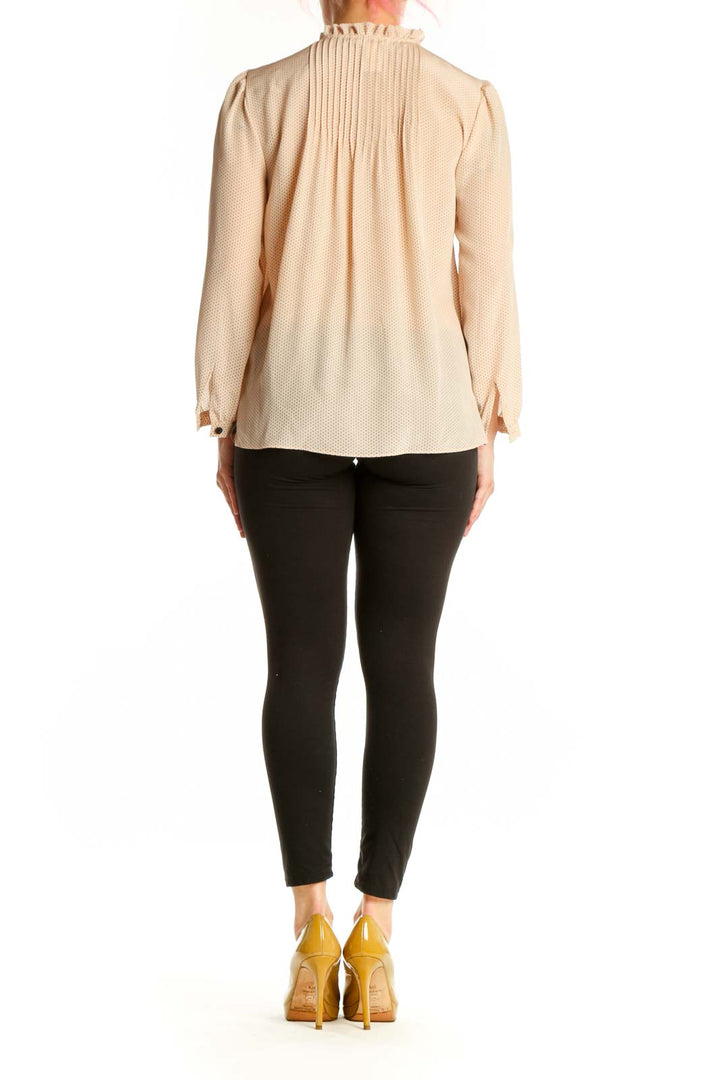Back view of cream silk pleated blouse showing relaxed fit and long sleeves