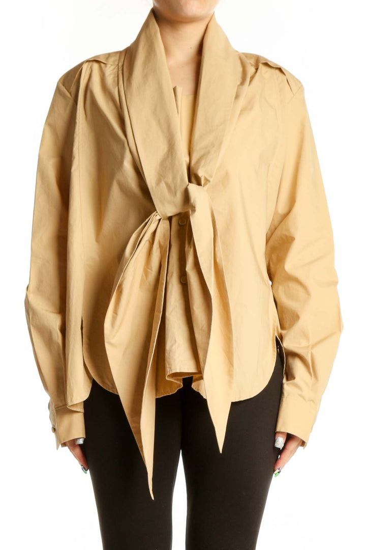 Beige cotton tie-front blouse with long sleeves and button cuffs, front view