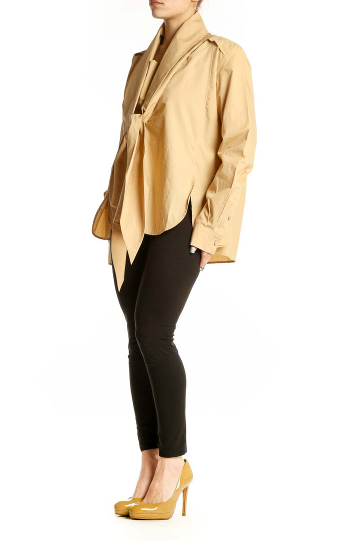 Beige cotton tie-front blouse with long sleeves and button cuffs, front view