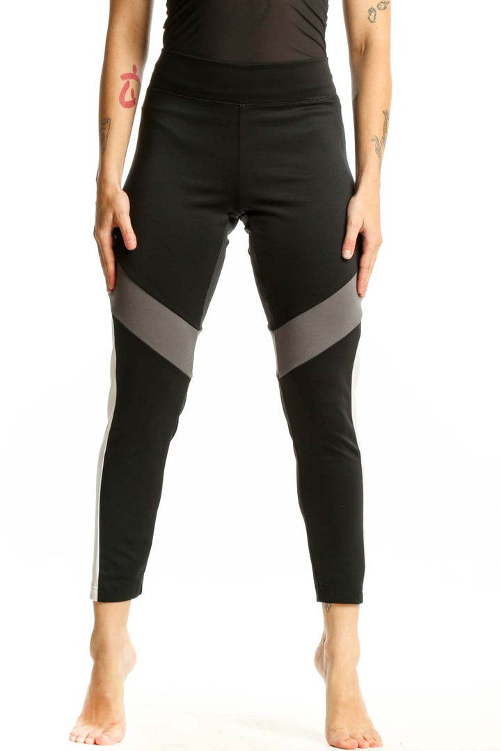 Adidas black colorblock leggings with gray and white paneling, front view showing high-waisted design and cropped length