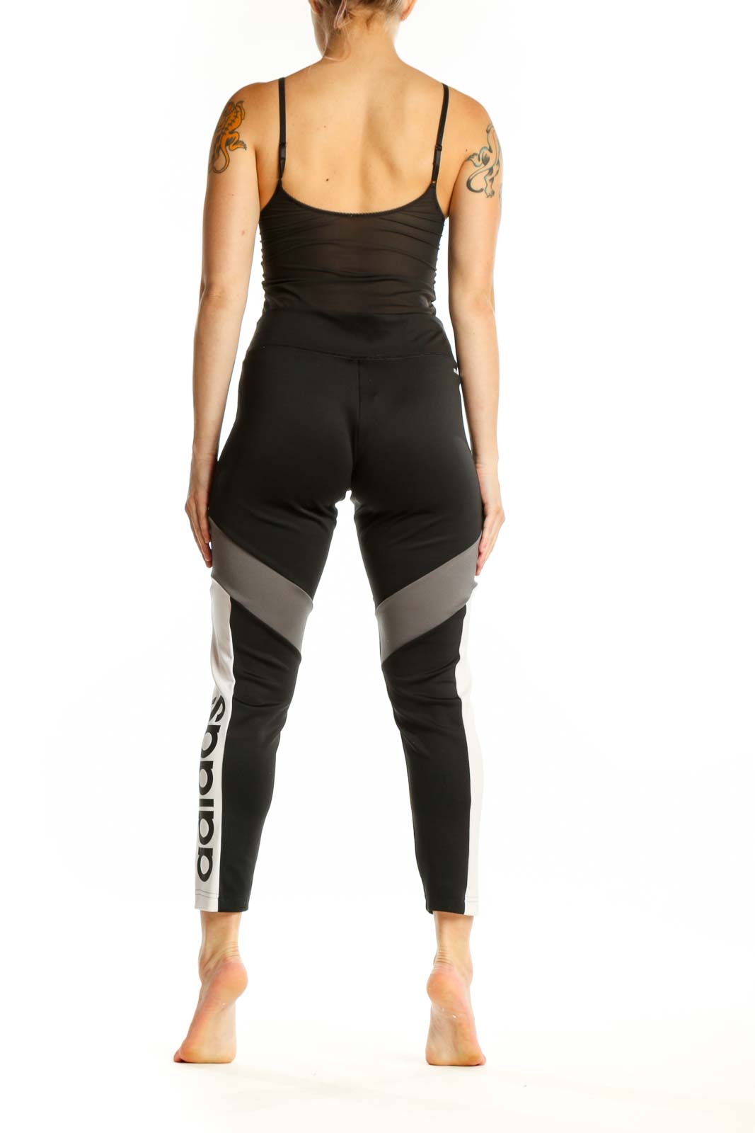 Adidas black colorblock leggings back view displaying Adidas branding on lower leg and colorblock paneling detail