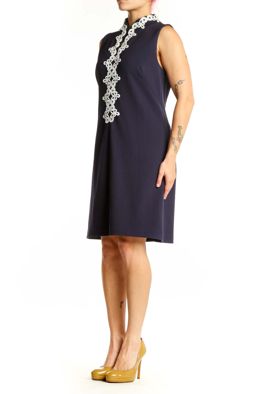 Navy sleeveless shift dress with white lace trim down center front, worn by model showing elegant A-line silhouette