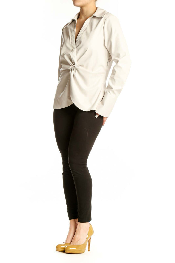 Cream faux-leather twist-front blouse with long sleeves and collared neckline, front view