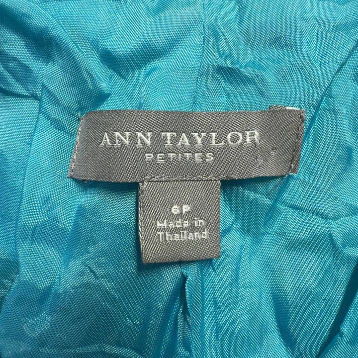 Tag view of turquoise petite blazer showing tailored fit and cropped length