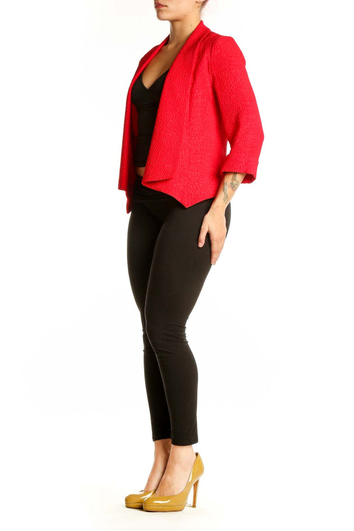 Red textured blazer by Alberto Makali with open-front design and three-quarter sleeves, worn with black crop top