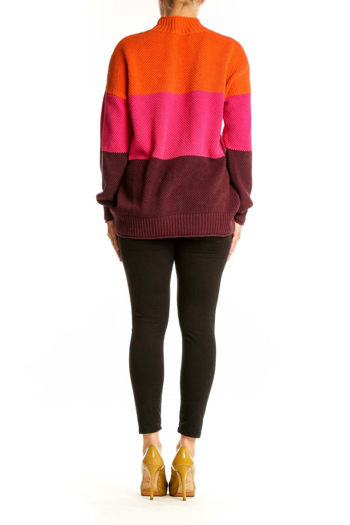 Back view of orange colorblock knit pullover sweater showing horizontal stripe design and relaxed fit