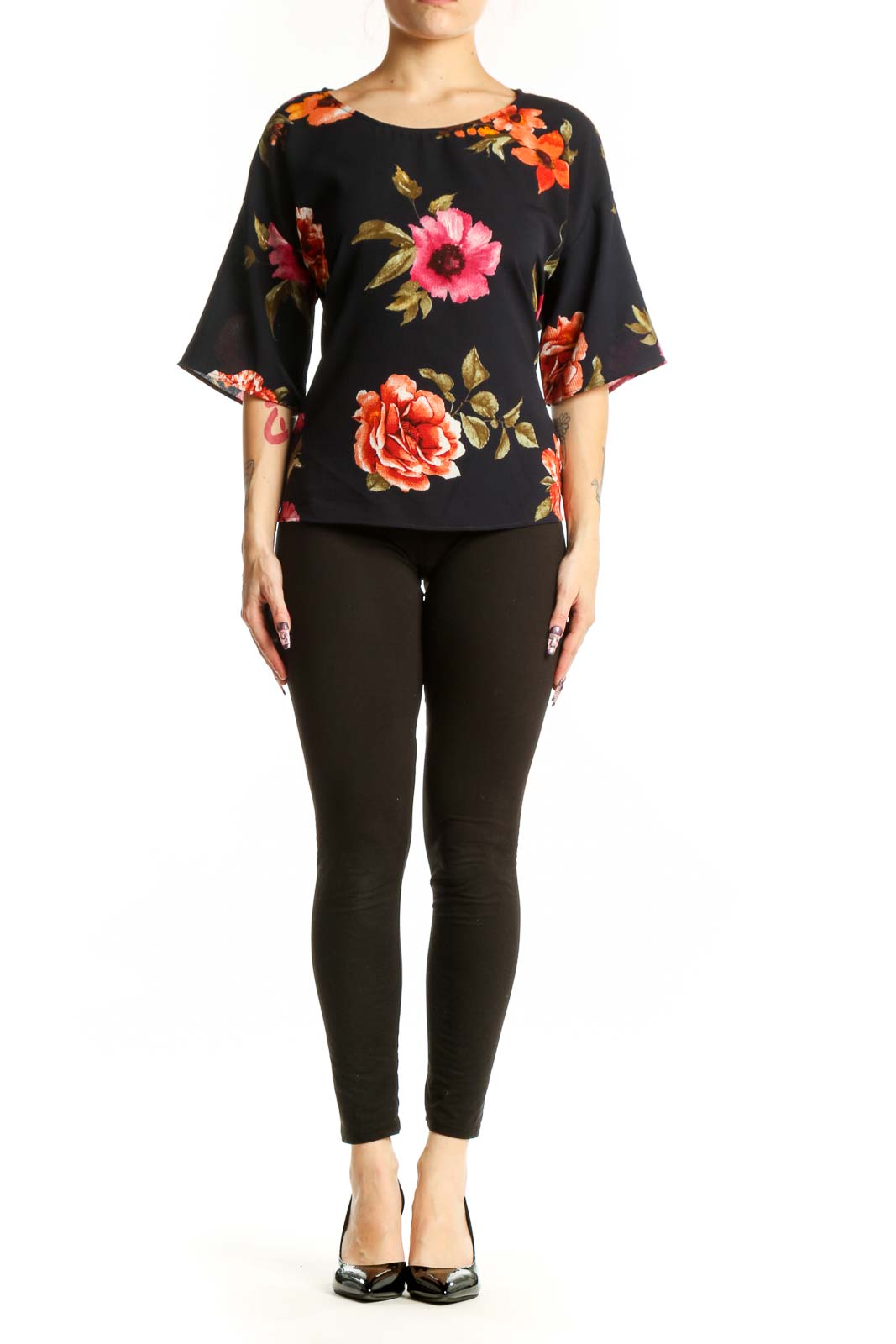 Black floral half sleeve top with vibrant red, pink, and orange roses and golden leaves, front view on model
