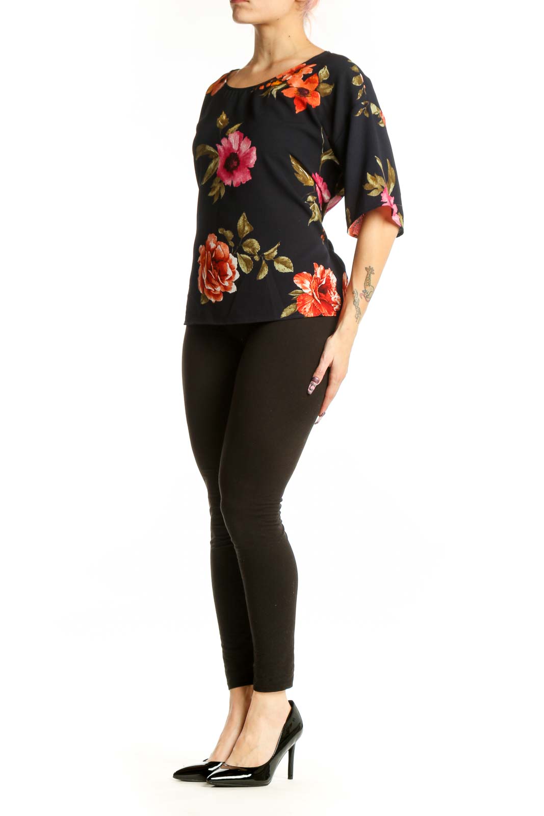 Black floral half sleeve top with vibrant red, pink, and orange roses and golden leaves, front view on model