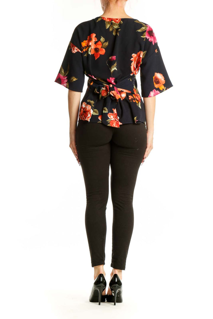 Black floral half sleeve top back view showing botanical print design and relaxed fit silhouette