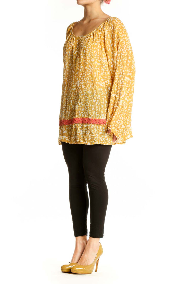 Yellow floral print cotton blouse with bell sleeves and coral trim detail, front view