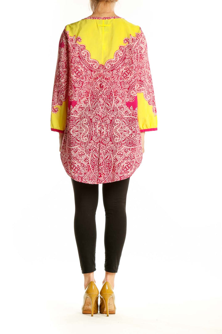 Back view of pink ornate paisley tunic top by Yoana Baraschi showing full length and magenta side panels with yellow trim
