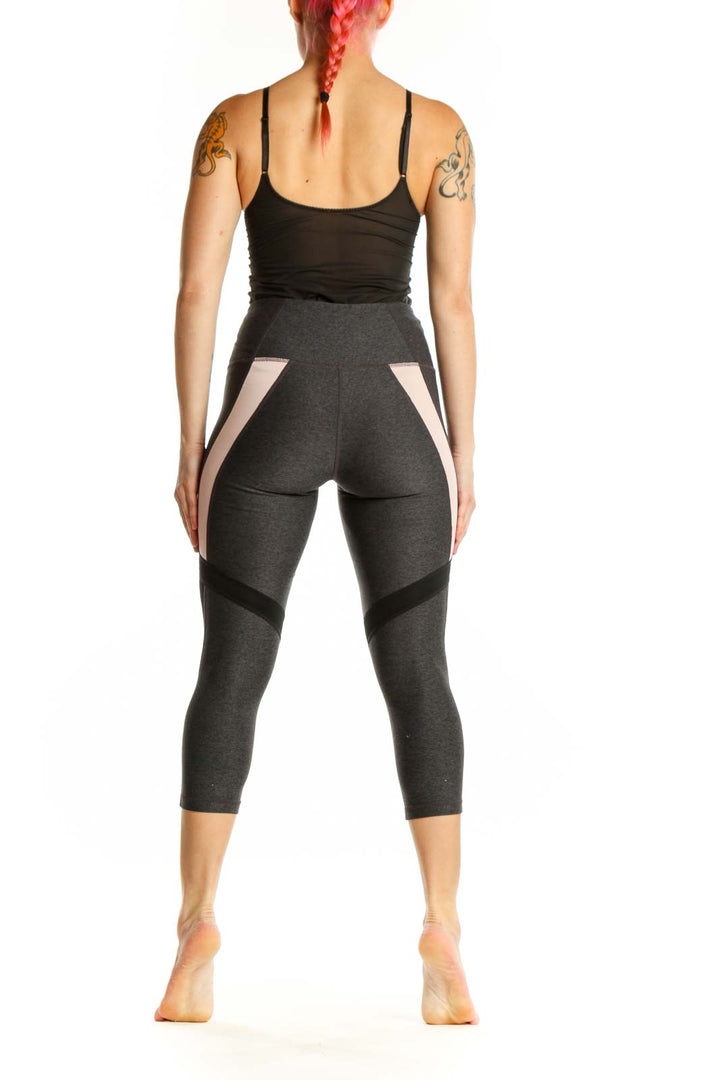 Back view of charcoal capri leggings showing mesh panel details on calves