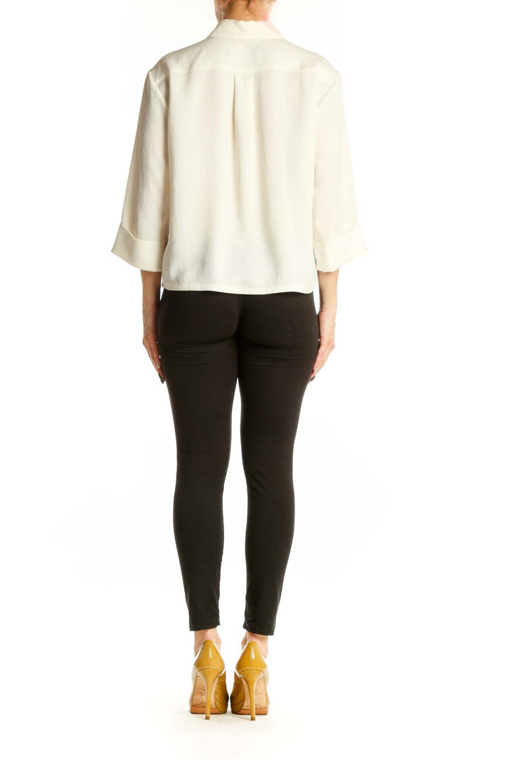 Back view of cream collared blouse showing button-up closure and relaxed fit silhouette
