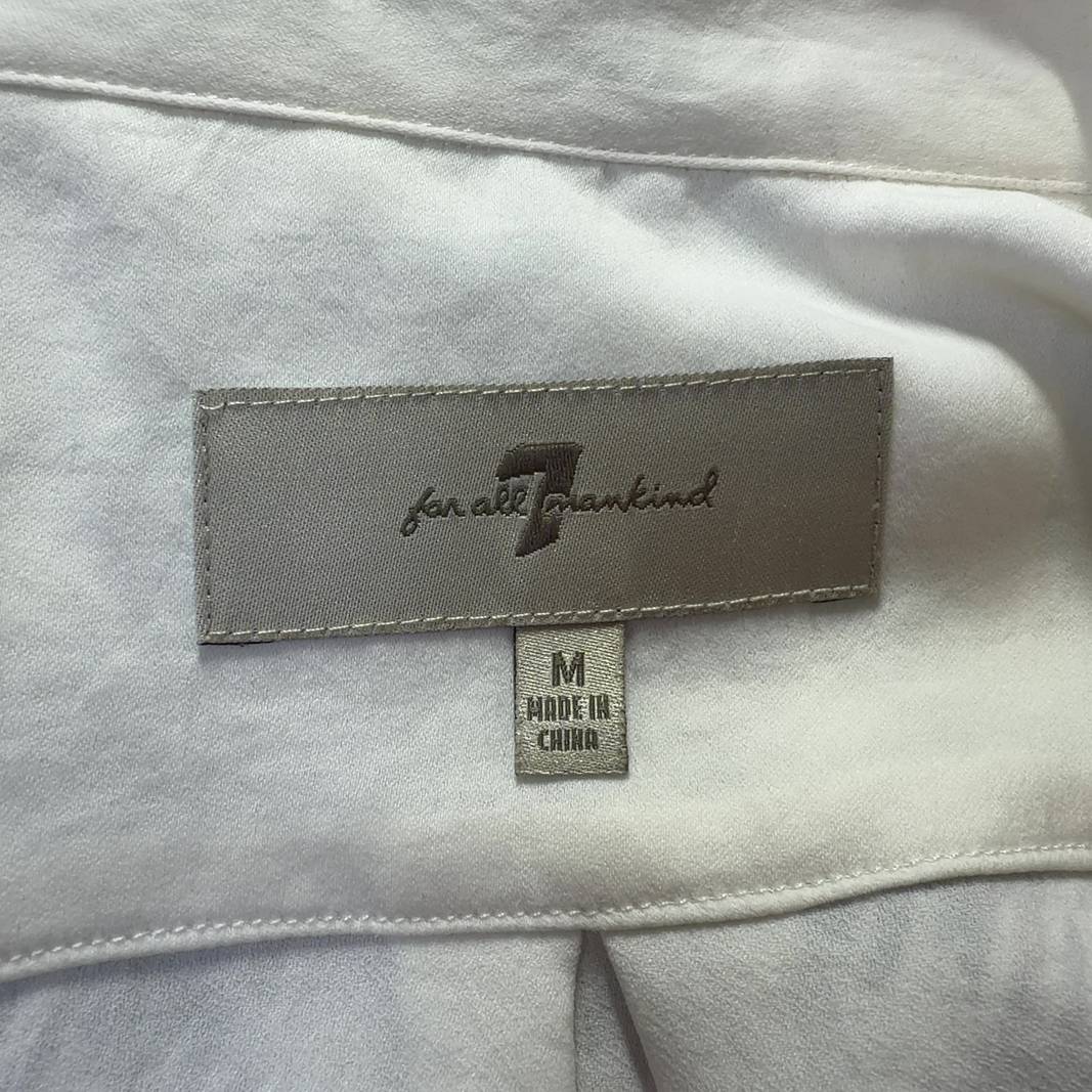 Tag view of cream collared blouse showing button-up closure and relaxed fit silhouette
