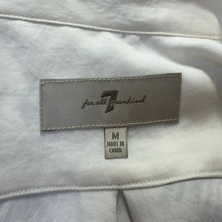 Tag view of cream collared blouse showing button-up closure and relaxed fit silhouette
